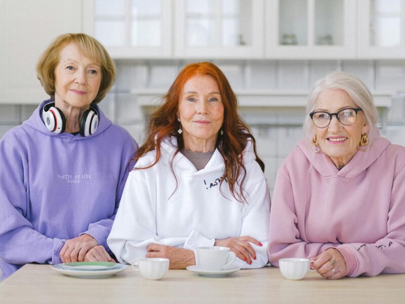 happy elderly women sitting at table with coffee