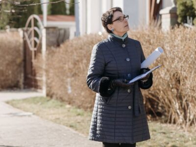 woman in blue coat standing on sidewalk